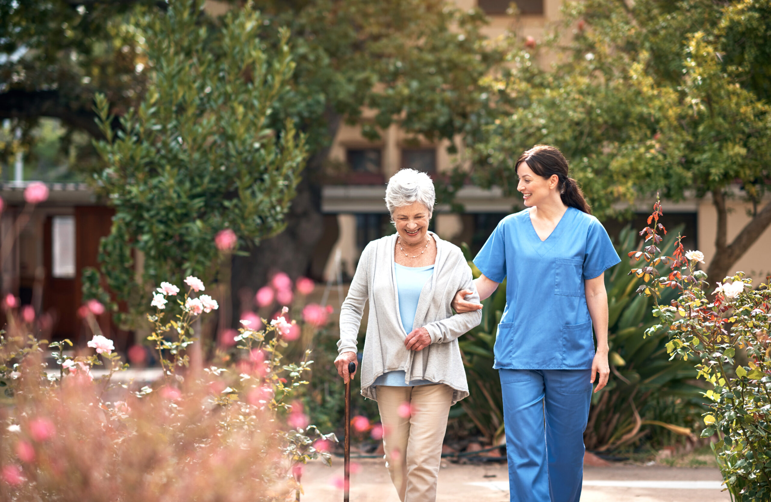 caretaker walking with elderly woman