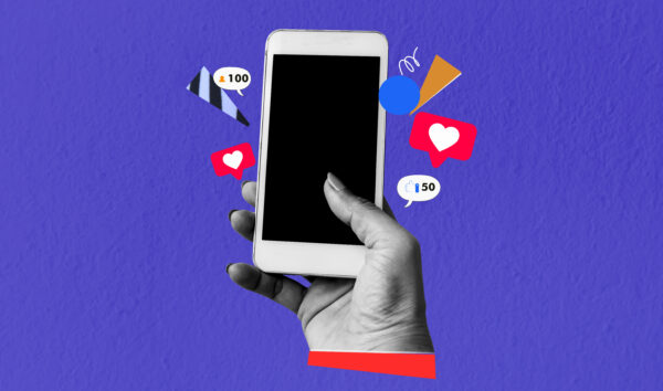 A hand holds a phone with digital icons popping out of it